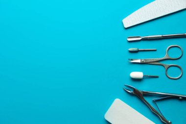 Mavi arka planda manikür, pedikür ve tırnak tasarımı için araçlar seti