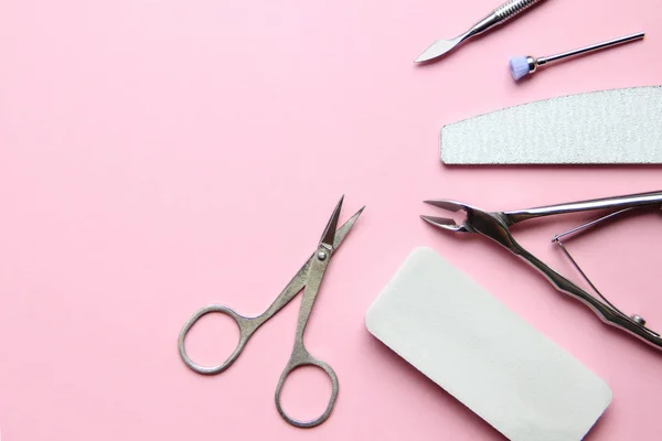 Basic tools for manicure and pedicure on a pink background
