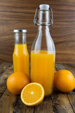 natürmort fotoğraf portakal suyu, portakal suyu ahşap arka plan üzerinde cam şişelerde.