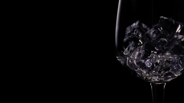 Wodka Einem Glas Mit Eiswürfeln Zeitlupe Nahaufnahme Auf Schwarzem Hintergrund — Stockvideo