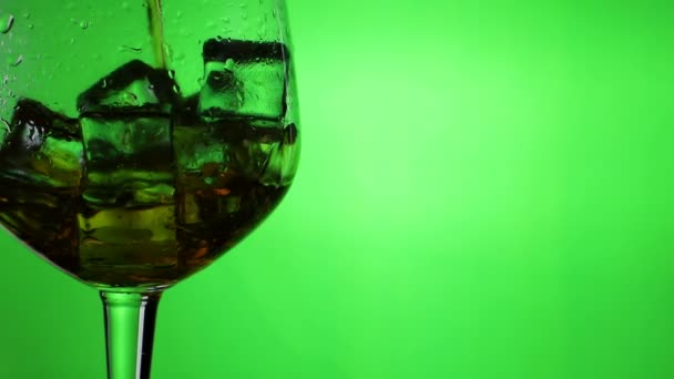 Виски Наливают Стакан Кубиками Льда Замедленной Съемке Крупным Планом Зеленом — стоковое видео
