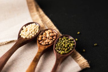 fasulye, yeşil bezelye, mercimek tahta kaşıklar üzerinde ahşap arka plan izole Tarih koleksiyonu kümesi. 