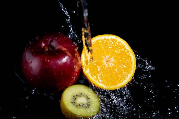 Manzana Roja Naranja Kiwi Salpicaduras Sobre Fondo Negro —  Fotos de Stock