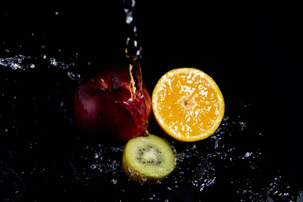 Manzana Roja Naranja Kiwi Salpicaduras Sobre Fondo Negro —  Fotos de Stock