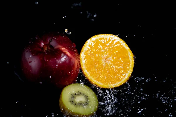 Manzana Roja Naranja Kiwi Salpicaduras Sobre Fondo Negro — Foto de Stock