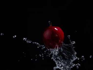 siyah arka plan üzerinde kırmızı elma sıçrama