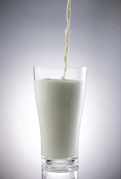 牛乳を背景に注ぎ — ストック写真