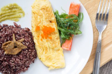 Plaka üzerinde omlet ile pirinç