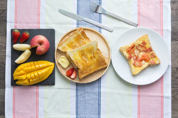 Frukost, rostat bröd med smör och frukt — Stockfoto