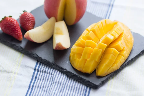 Mango y manzana en un plato de piedra negra — Foto de Stock