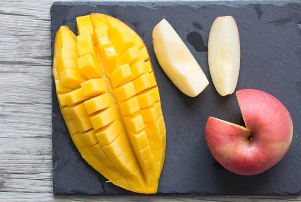 Mango y manzana en un plato de piedra negra — Foto de Stock