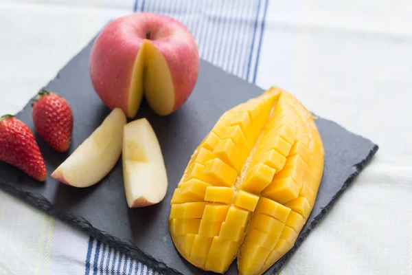 Mango y manzana en un plato de piedra negra — Foto de Stock