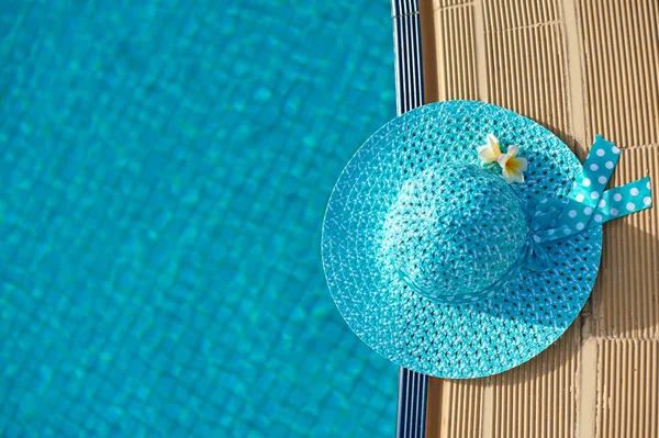 Sombrero de playa junto a la piscina, vista superior con espacio para su texto — Foto de Stock