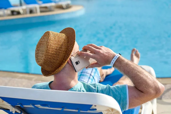 Homme utilisant le téléphone portable en vacances au bord de la piscine à l'hôtel, concept d'un pigiste travaillant pour lui-même en vacances et Voyage — Photo