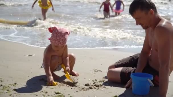 4K View ребенок играет в песке на пляже Счастливая белая девочка, ребенок весело с песчаными игрушками — стоковое видео