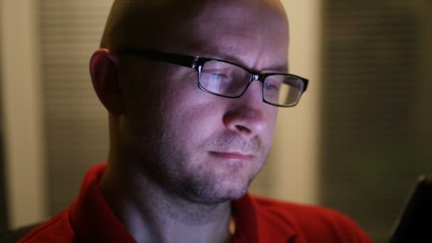 Портрет молодого чоловіка в окулярах, який працює вночі. крупним планом — стокове відео