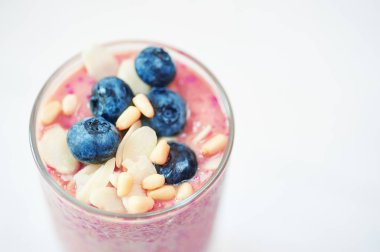 Kadeh pembe meyve smoothies muzlu süt ya da beyaz arka plan, metin, çiğ gıda kavramı için bir yer ile kahvaltı vegan kokteylde.