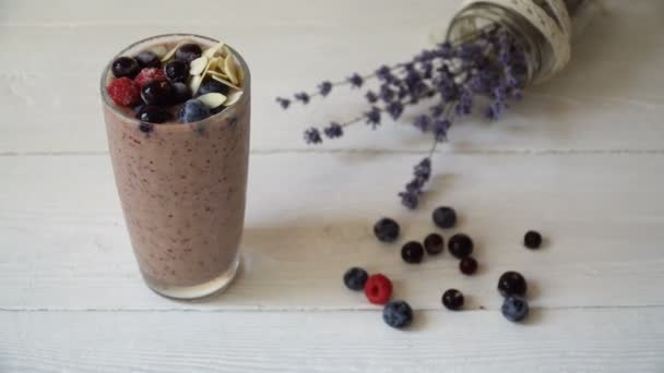 Batido marrón mezclado con ingredientes o cóctel sobre fondo blanco, desayuno vegano con un lugar para su texto, concepto de desintoxicación de alimentos crudos — Vídeos de Stock