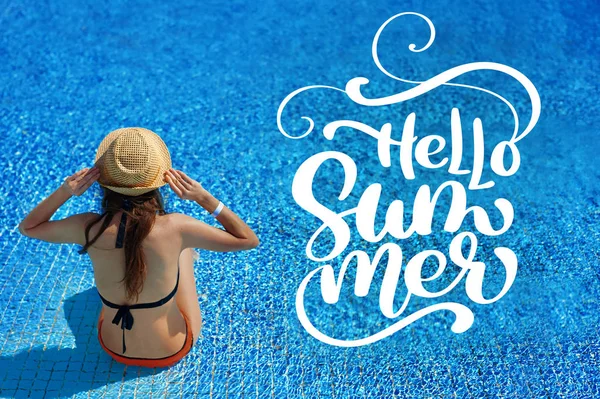 Женщина в соломенной шляпе расслабляется возле роскошного бассейна и букв Hello Summer, concept time to travel — стоковое фото