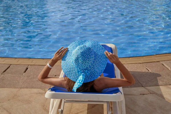 Žena v klobouku, na dovolené na lehátko na okraji bazénu léto v přírodě, pojem relax a cestování — Stock fotografie