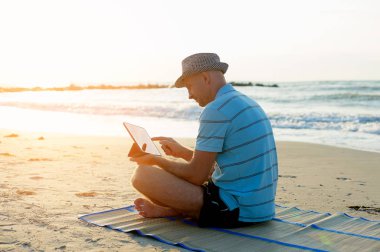 Komuta sizde onun laptopunda plaj deniz günbatımı, freelancer kavramı seyahat sırasında çalışma