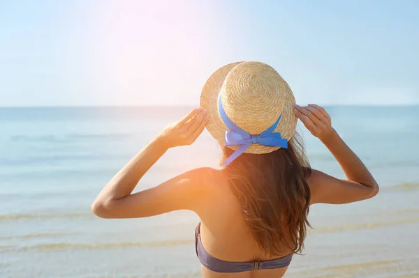 Sommer-Lifestyle-Porträt einer hübschen jungen, sonnengebräunten Frau mit Hut. Das Leben genießen und am Strand sitzen, Zeit zum Reisen. Blick auf das Meer — Stockfoto