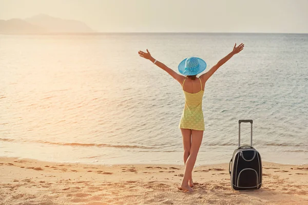 Beautiful young woman standing with suitcase on the wonderful sea background, concept of time to travel — Stock Photo, Image