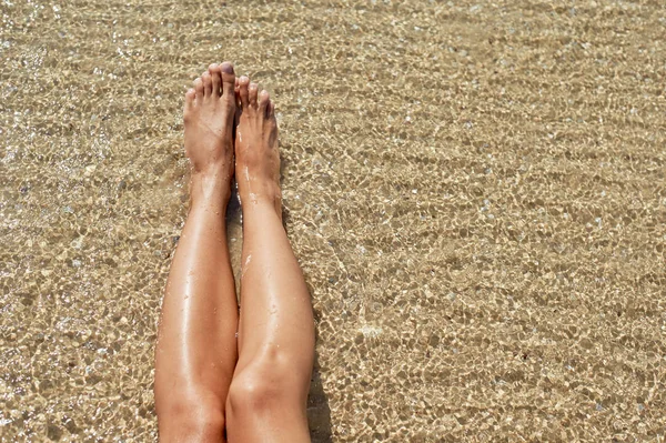 Female feet against the sea on the summer beach, time to travel. Empty place for a text — Stock Photo, Image