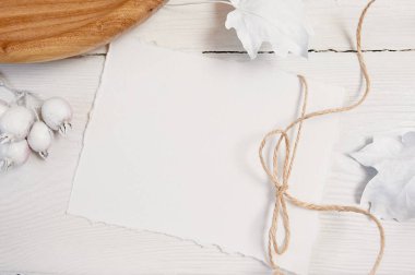 Mockup sonbahar. Beyaz kağıt yaprağı, Çamaşır ipi, ahşap yer, beyaz kabak, meyve ve yaprakları, ahşap arka plan üzerinde beyaz kağıdın. Rustik tarzda Şükran günü için tebrik kartı