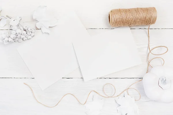 Witte pompoen, bessen en bladeren en twee witte vellen papier en linnen touw op een houten mock up herfst achtergrond. Wenskaart voor Thanksgiving Day in rustieke stijl met ruimte voor uw tekst. Flat — Stockfoto