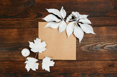 Boş kraft kağıdın düz yatıyordu mockup sanat, resim veya el yazı kompozisyon kopya alanı, en iyi görünüm için. Sonbahar kompozisyon koyu kahverengi ahşap artalan üzerinde beyaz yaprakları yapılmış