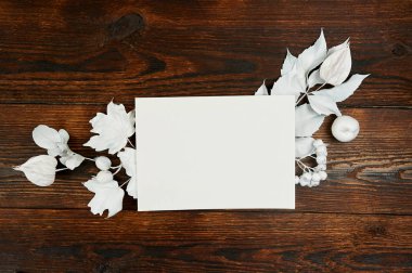 Parça kağıt beyaz boş düz yatıyordu mockup sanat, resim veya el yazı kompozisyon kopya alanı, en iyi görünüm için. Sonbahar kompozisyon koyu kahverengi ahşap artalan üzerinde beyaz yaprakları yapılmış