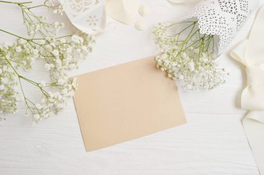 Soyut tatil arka plan, kraft Beyaz ahşap masa üzerinde küçük süslemeler arasında yalan kağıdın. Sanat, resim veya el yazı kompozisyon kopya alanı, en iyi görünüm için düz yatıyordu mockup