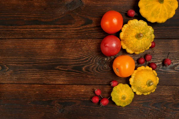 Cornice decorativa autunnale con zucca e pomodoro rosso su sfondo di legno marrone scuro piatto lay mockup per la tua arte, foto o scritte a mano. Composizione spazio di copia, vista dall'alto — Foto Stock