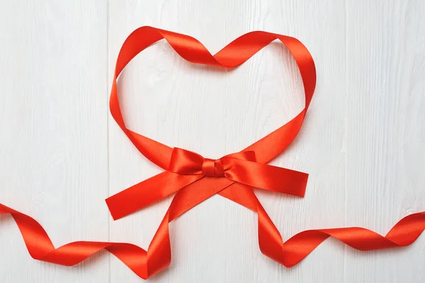 Corazón de cinta roja sobre fondo de madera blanca. concepto de amor romántico. fondo del día de San Valentín para cumpleaños, vacaciones, fiesta, boda. Puesta plana — Foto de Stock