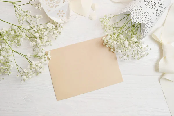 Soyut tatil arka plan, kraft Beyaz ahşap masa üzerinde küçük süslemeler arasında yalan kağıdın. Sanat, resim veya el yazı kompozisyon kopya alanı, en iyi görünüm için düz yatıyordu mockup