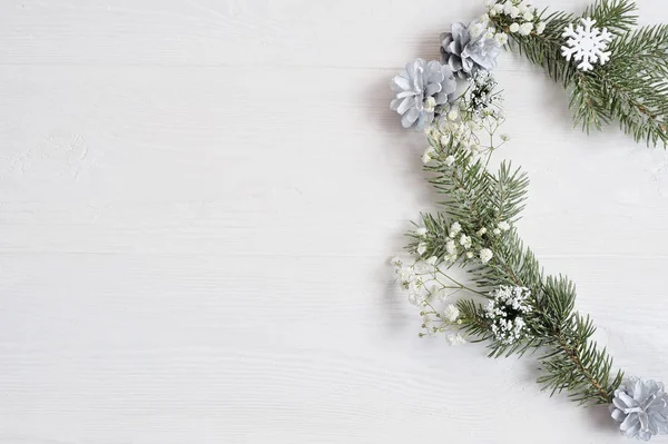 Maketa vánoční věnec ve formě srdce zdobené bílé sněhové vločky a kužely. Na bílém pozadí dřevěná — Stock fotografie