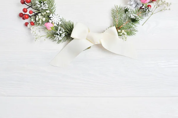 Mockup Metade da grinalda de Natal decorada com bagas vermelhas. Flat lay sobre um fundo de madeira branco, com lugar para o seu texto. Vista superior — Fotografia de Stock