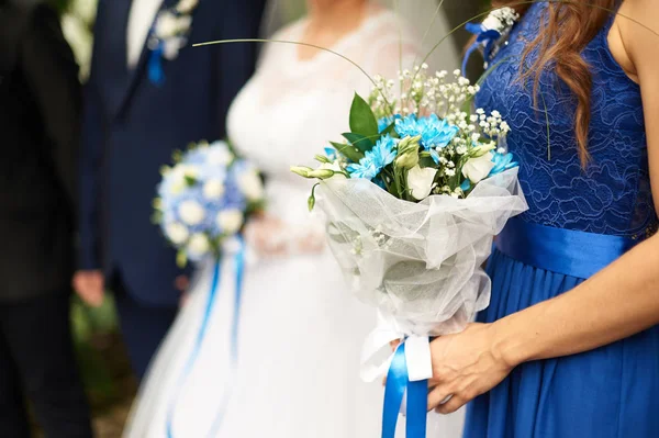 Beautiful bridal bouquet of roses and hydrangeas on the background bride and groom stand at a wedding ceremony — Stock Photo, Image