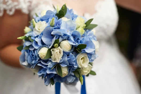 Νύφη που κρατάει στο χέρι της μια όμορφη γαμήλια ανθοδέσμη από τριαντάφυλλα και μπλε ορτανσίες — Φωτογραφία Αρχείου