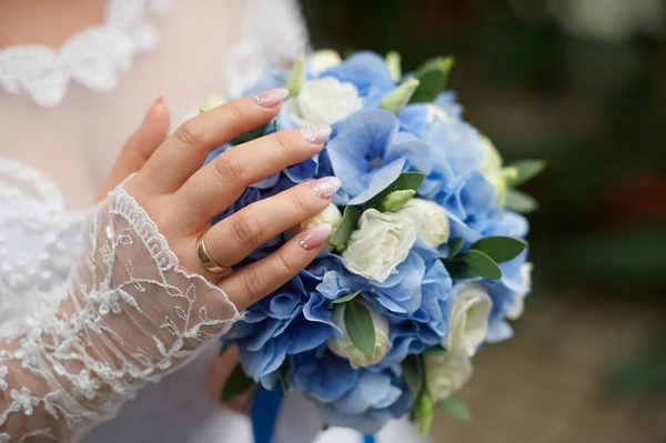 Novia sostiene en su mano un hermoso ramo de boda de rosas — Foto de Stock