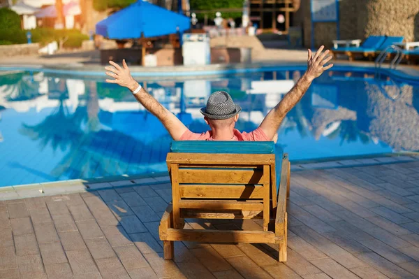 Joven con sombrero se encuentra en más alto cerca de la piscina para relajarse Descanso en Egipto, en Sharm El Sheikh — Foto de Stock