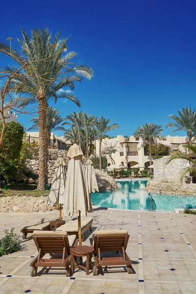 Sharm El Sheikh, Egypt - February 9, 2019: Five-star The Grand Hotel with palms and loungers near swimming pool in territory summer — Stock Photo, Image