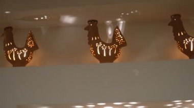 Kil vazo horozlar raf şeklinde. Mum içinde yanıyor. ev iç ve konfor