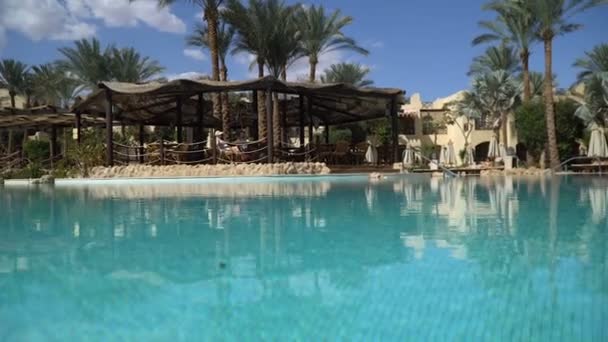 Sunny Hotel Resort met luxe blauw zwembad, glijbanen, palmbomen, strandparasols en ligbedden in Egypte. Rijke vakantie op het zonnige resort. Leeg Egyptisch hotel met zwembad. Rustig maar. — Stockvideo