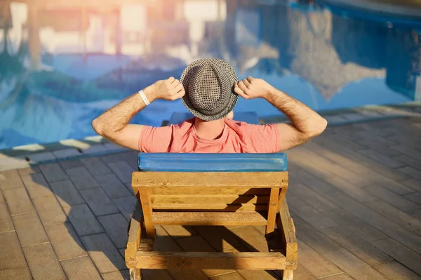 Jeune homme reposant sur des chaises longues par la natation Détendez-vous dans la piscine été sur une chaise longue à l'hôtel sur le fond du coucher du soleil en Egypte, Sharm El Sheikh — Photo