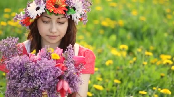 Mujer con corona en la cabeza recoge flores de lila y tulipán en el jardín. Mujer feliz jardinero con flores. Primavera y verano. Me encanta trabajar con plantas — Vídeos de Stock