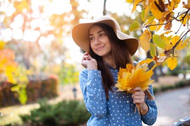 yapraklar sonbaharda bir sürü tutan güzel genç kadın