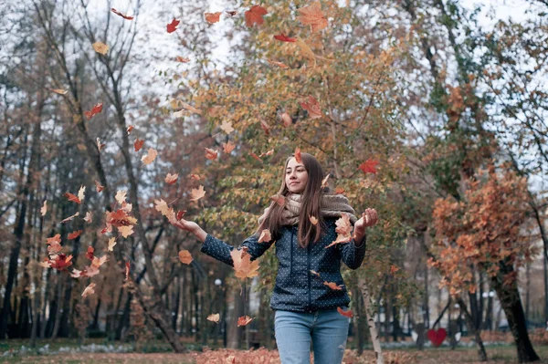 Szabadban életmód divat képe boldog szép lány dobott elhagyja a levegőben az őszi parkban — Stock Fotó