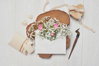 Calligraphic tüy çiçek ve bir mektup, kalp hediye kutusu, metin için yer ile Sevgililer Günü için tebrik kartı ile bir zarf. Düz lay, üstten görünüm fotoğraf mock up